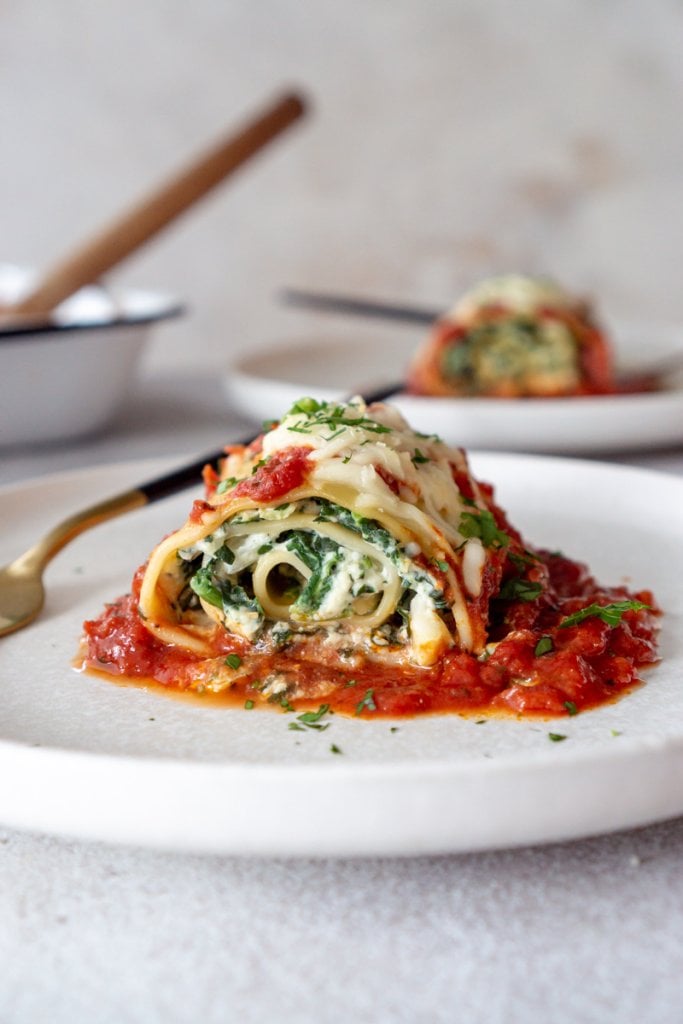 close up of a spinach lasagna roll on a plate