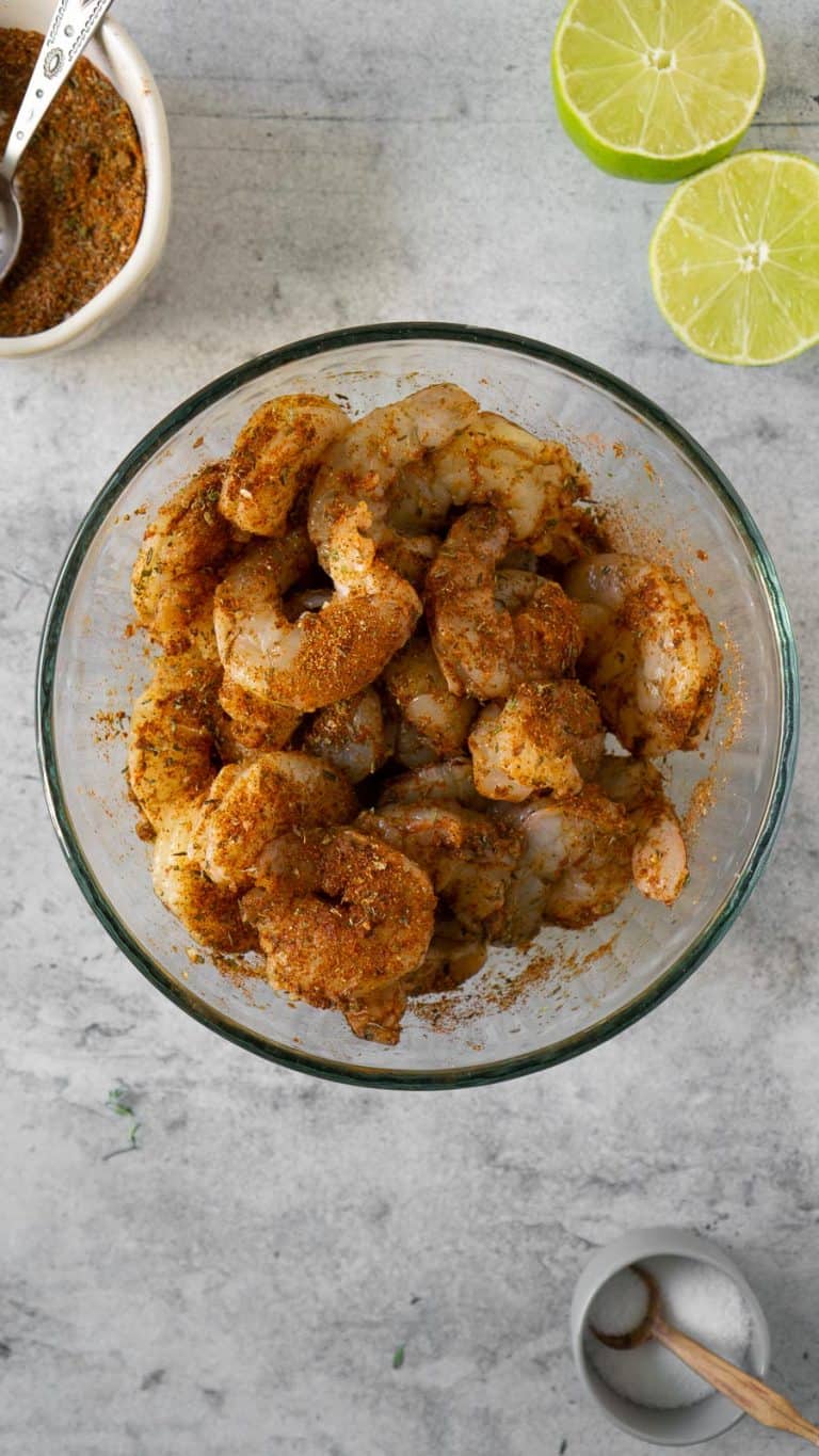 raw shrimp coated with blackened seasoning in a mixing bowl