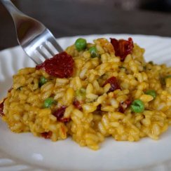 sun dried tomato risotto on a plate with a fork