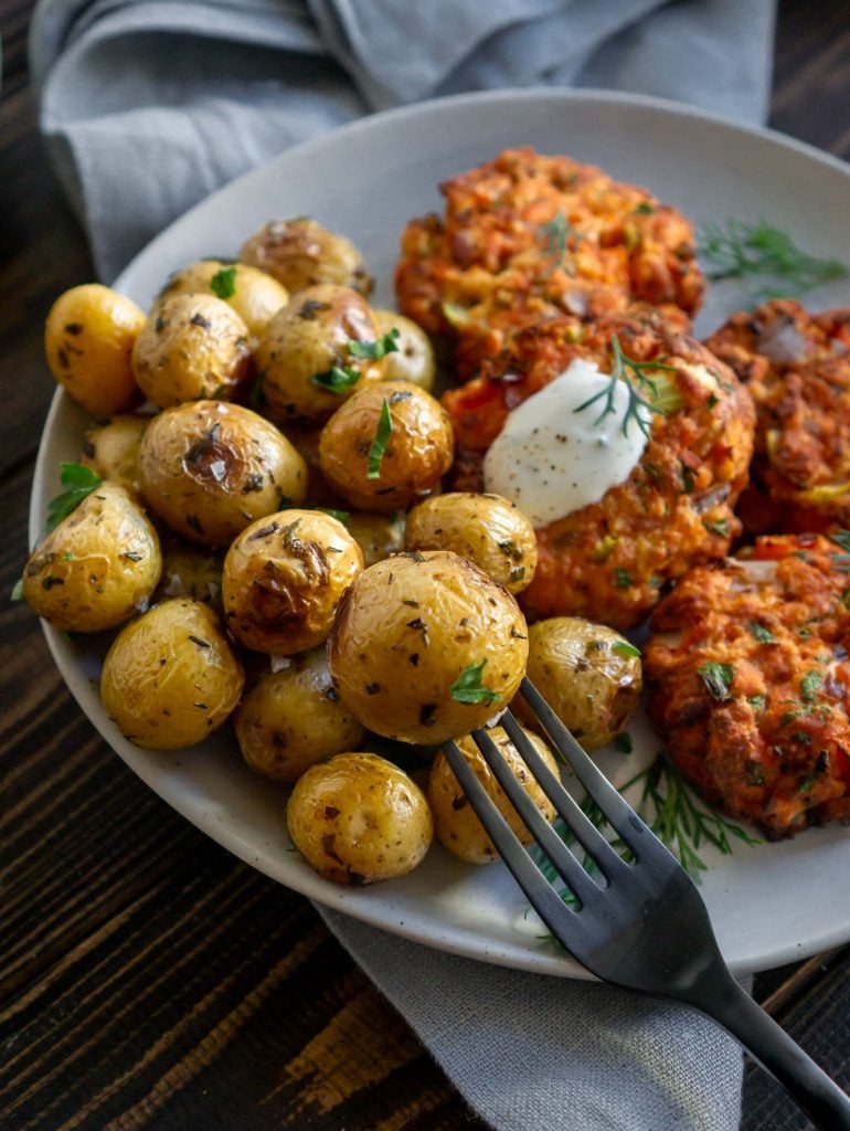 roasted mini potatoes on a fork with salmon cakes