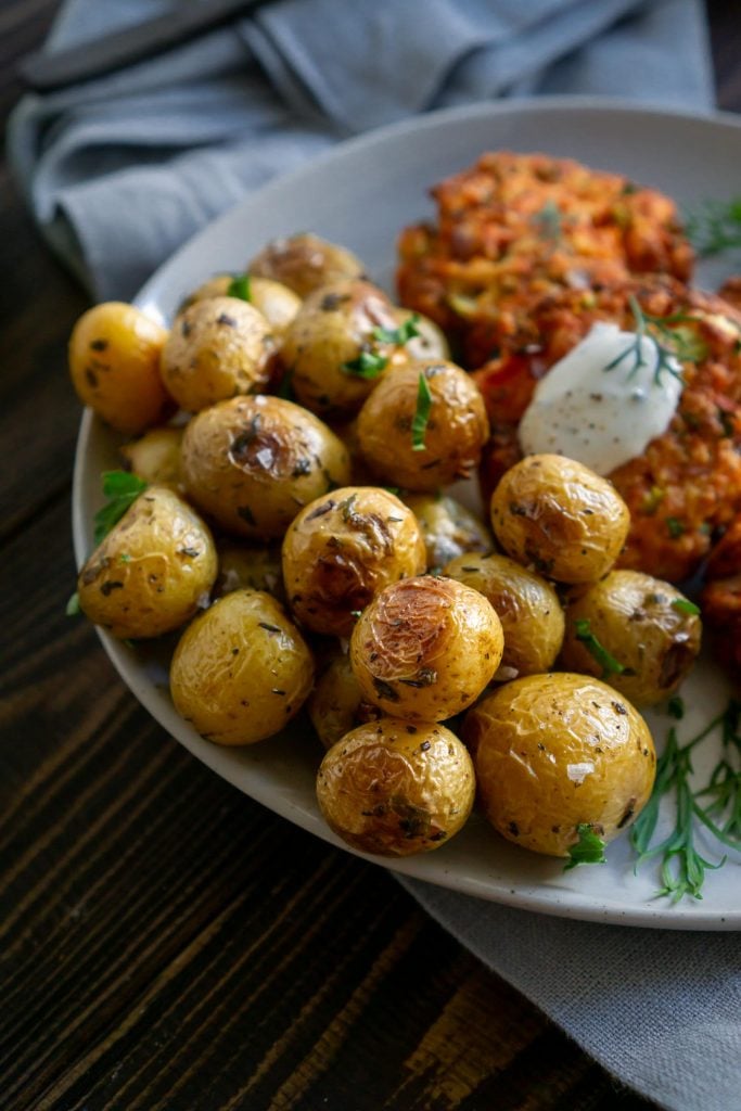 roasted mini potatoes on a plate with salmon cakes