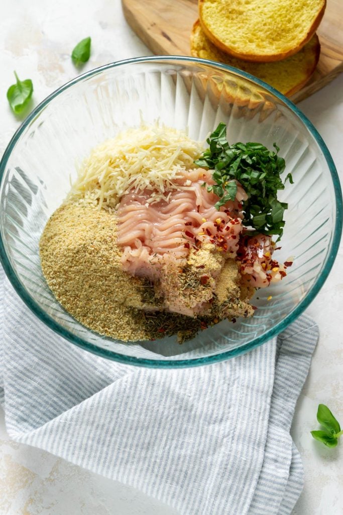 ground chicken, bread crumbs, basil, and red pepper flakes in a glass bowl