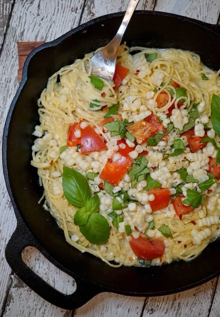 Baked brie spaghetti in a cast iron pan with a fork