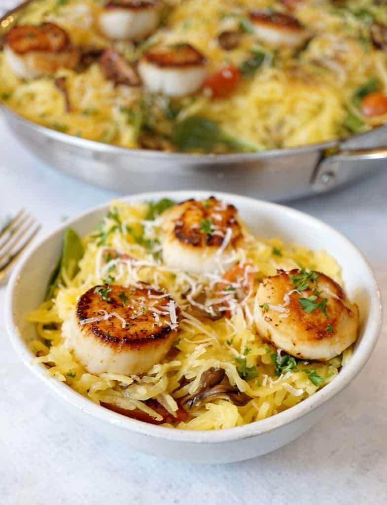 White bowl and large pan with spaghetti squash