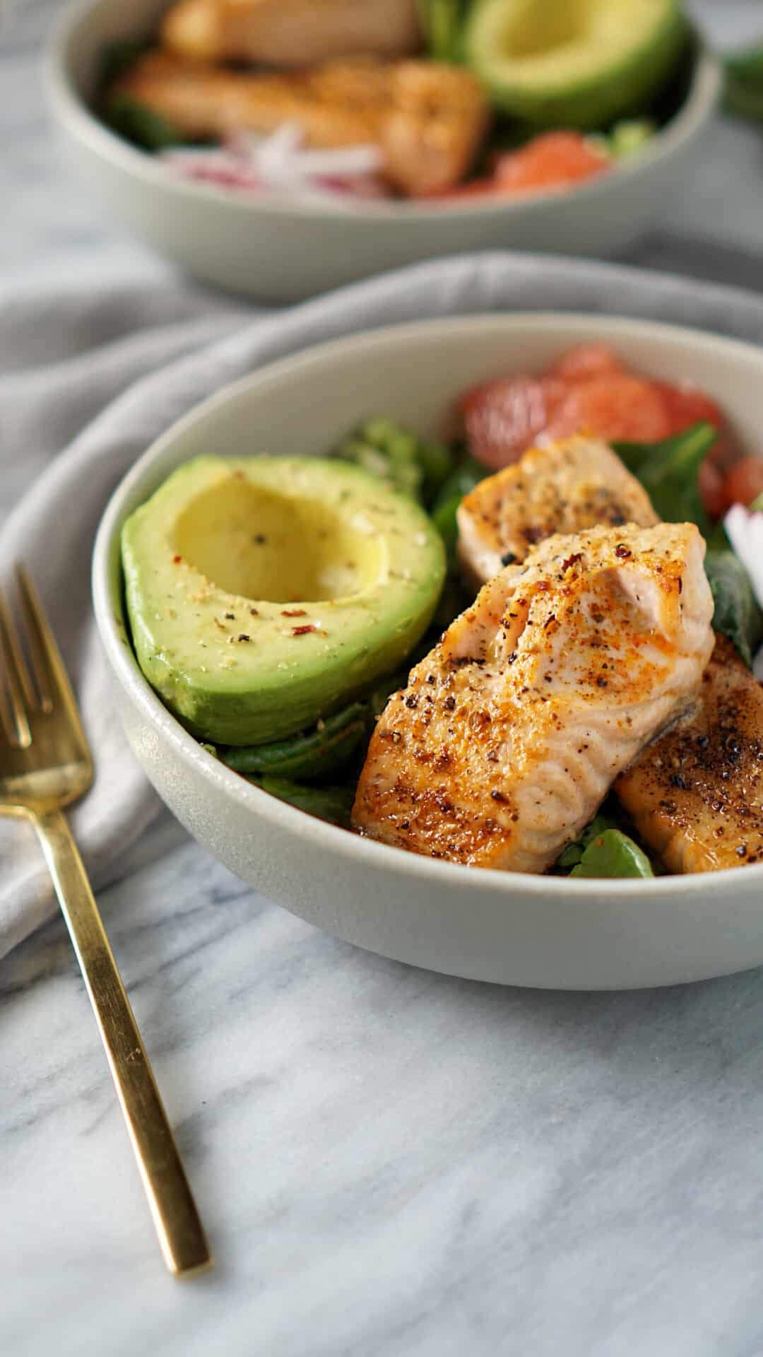 whole30 salmon bowl with gold fork and grey napkin