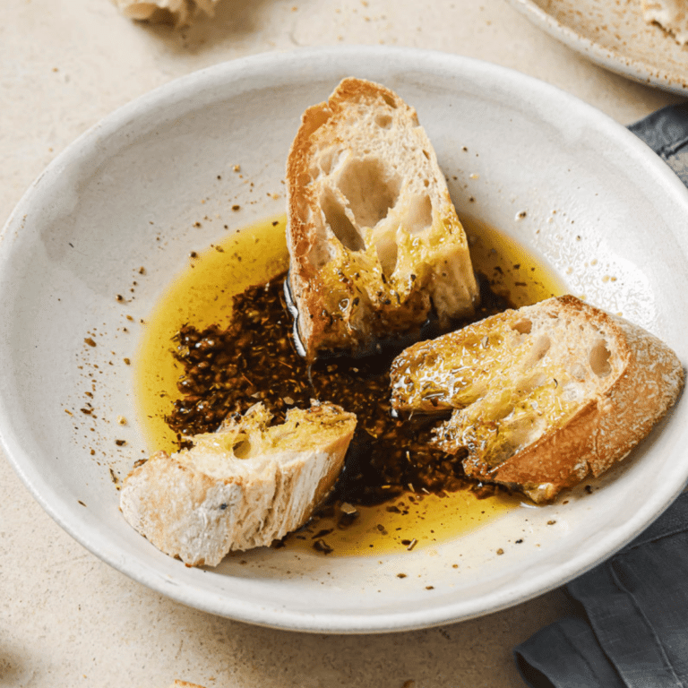 olive oil bread dip with sourdough bread in a white bowl,