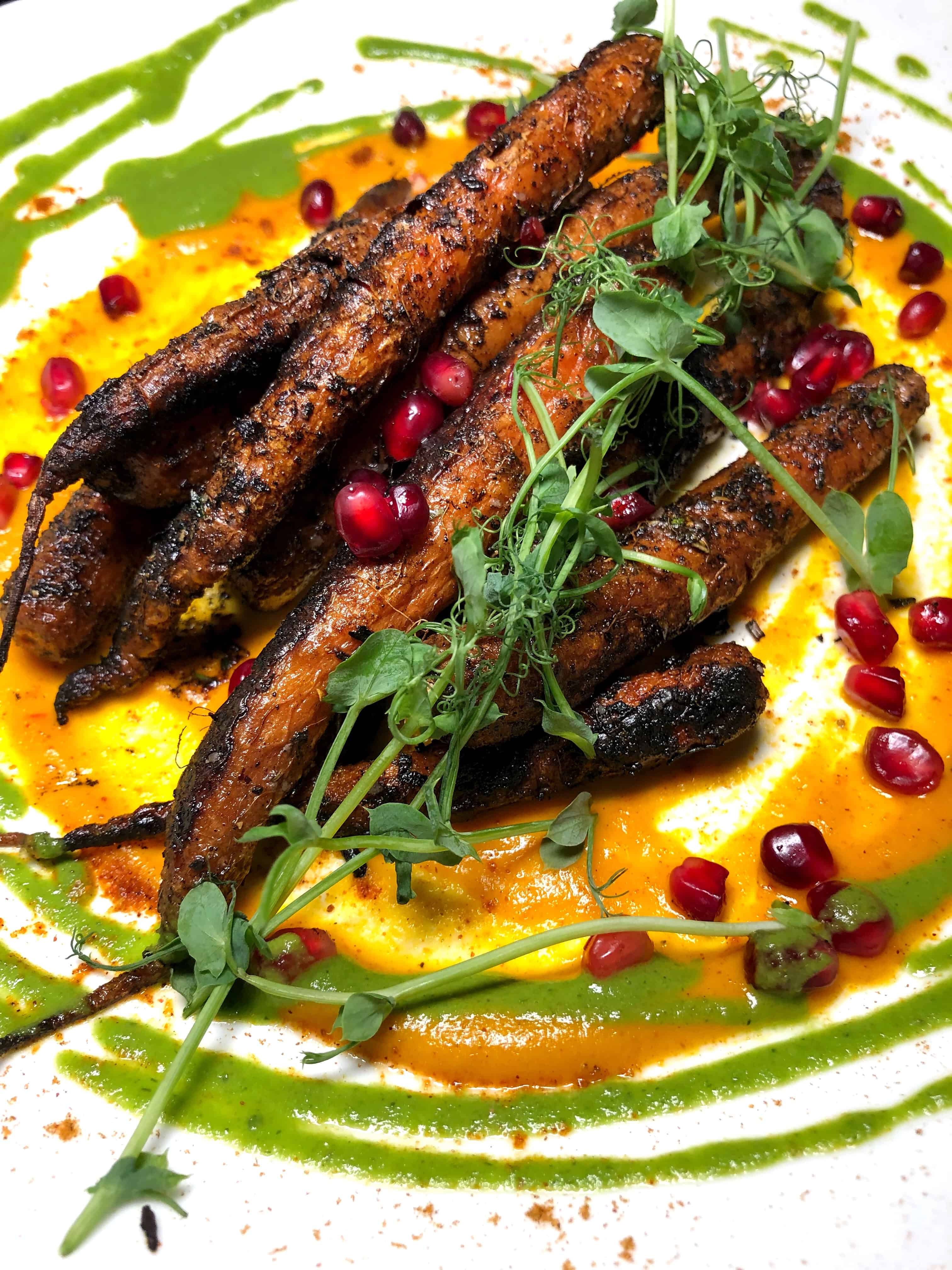 Charred carrots on a plate with sauce 