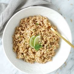Cilantro lime farro in a white bowl with a gold fork