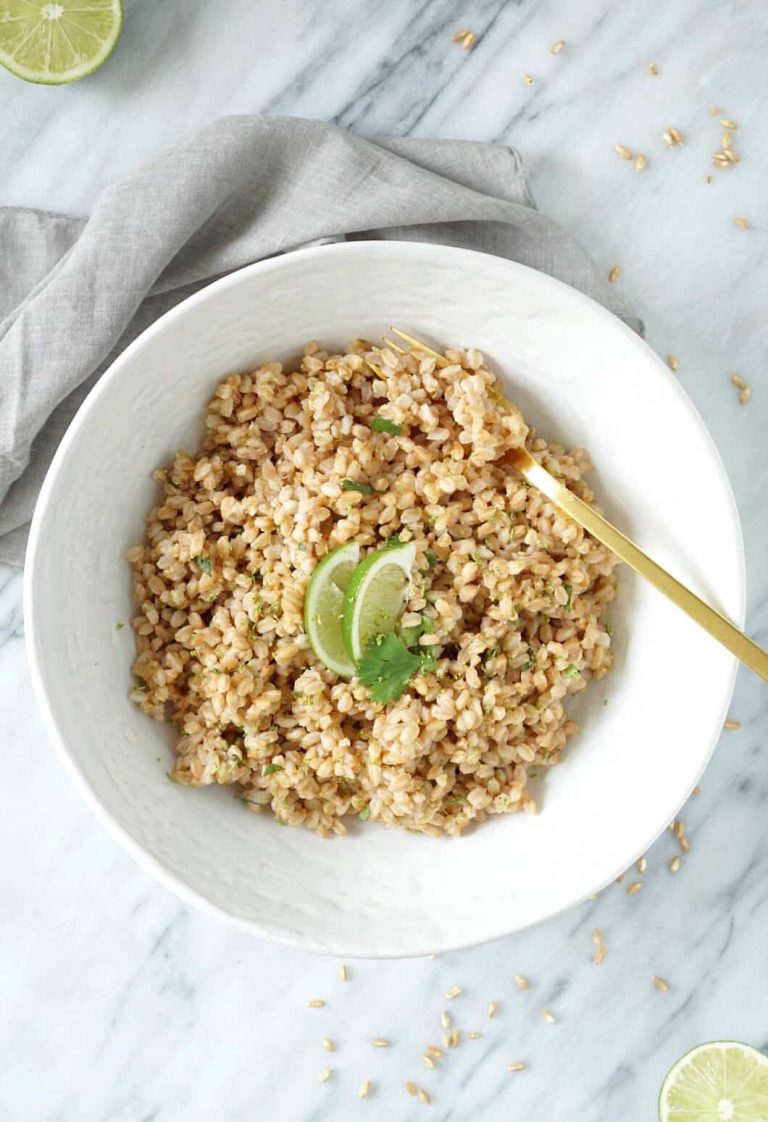 Cilantro lime farro in a white bowl with a gold fork