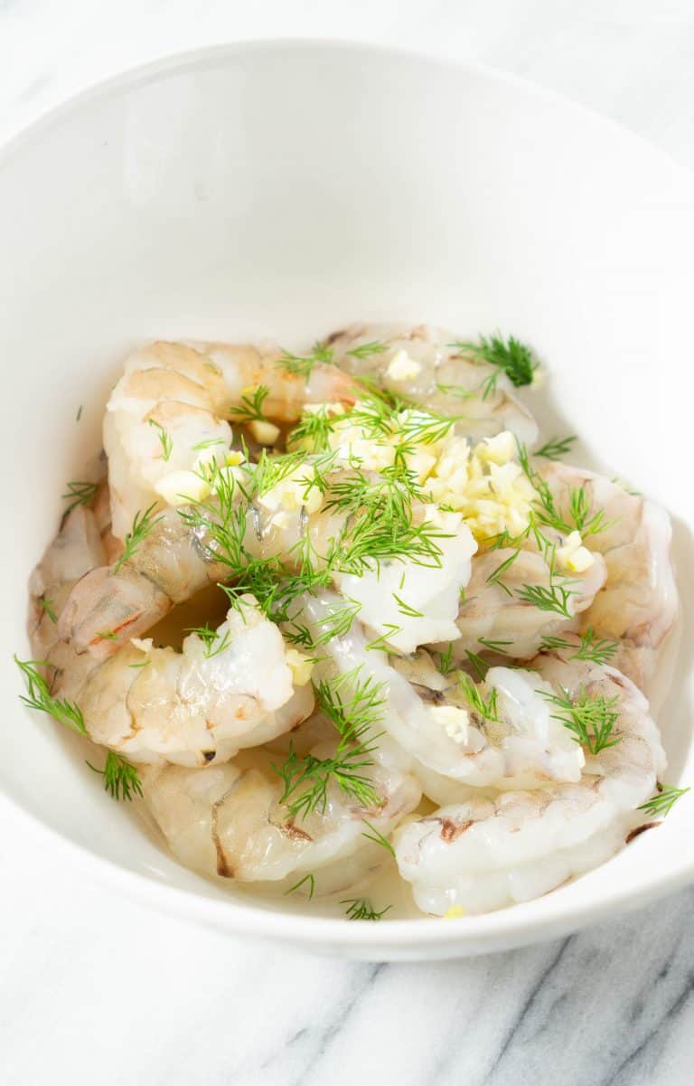 garlic butter shrimp marinating in a white bowl