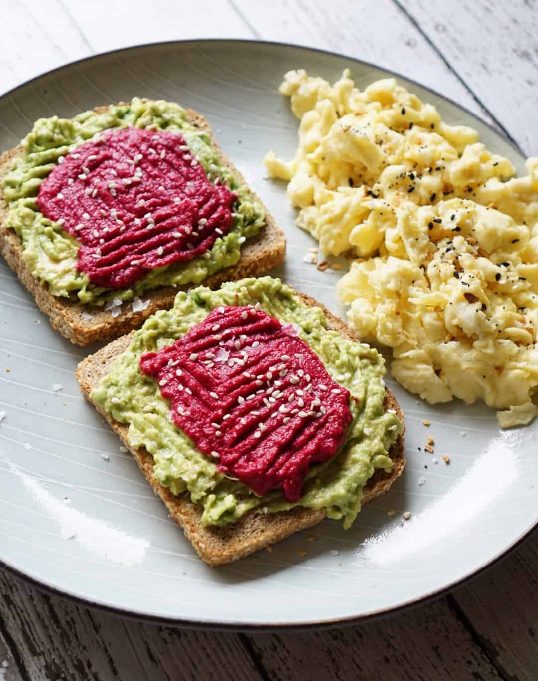 Avocado toast with scrambled eggs on a grey plate