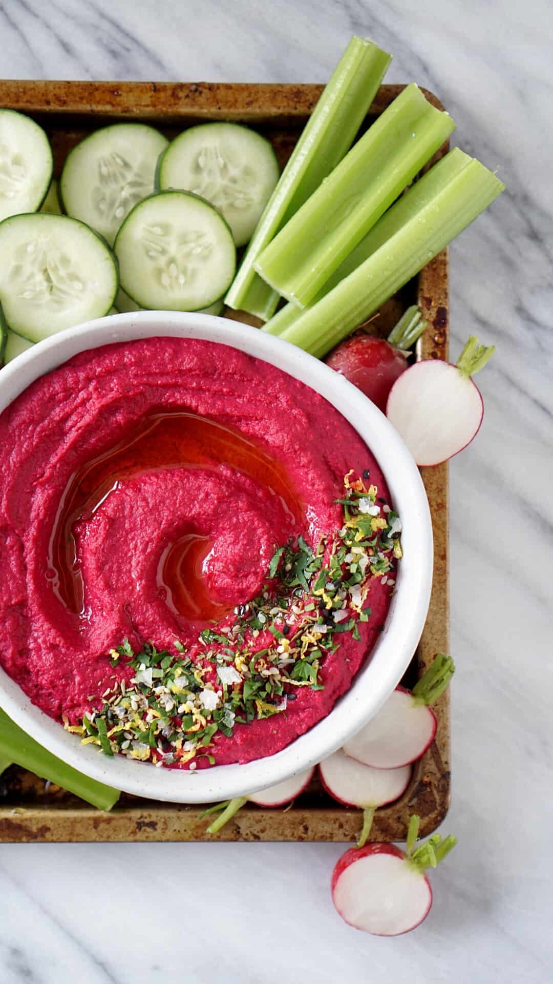 Beet hummus in a bowl with vegetables