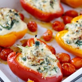 Stuffed peppers in a white pan with tomatoes