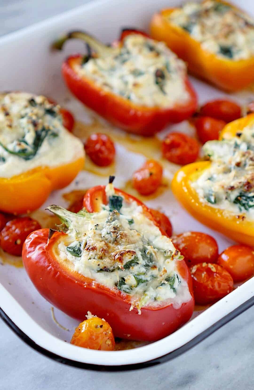 Stuffed peppers in a white pan with tomatoes
