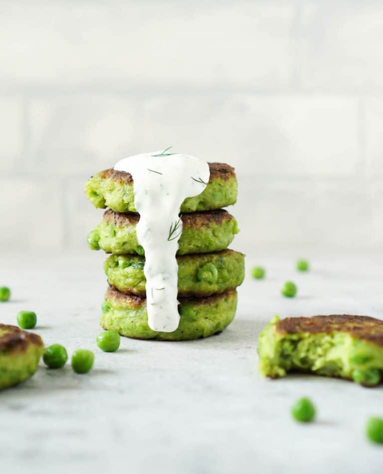 4 pea fritters stacked with dill yogurt sauce