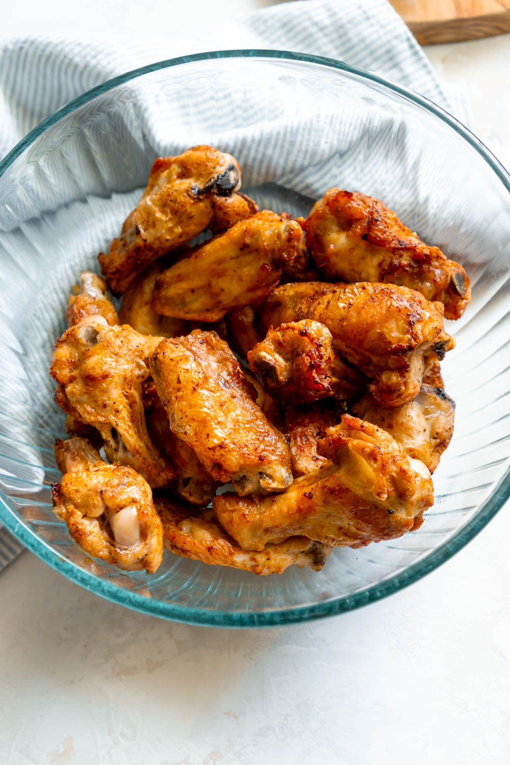 Crispy air fryer chicken wings in a glass bowl.