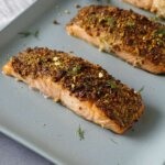 air fryer salmon on a blue serving tray with a black serving fork