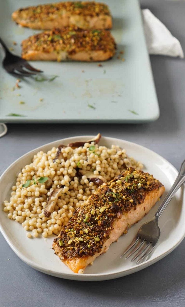 air fryer salmon on a white plate with couscous and a fork