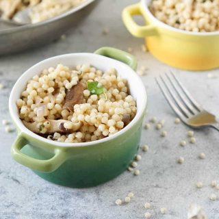 israeli couscous recipe in two colored bowls with a fork