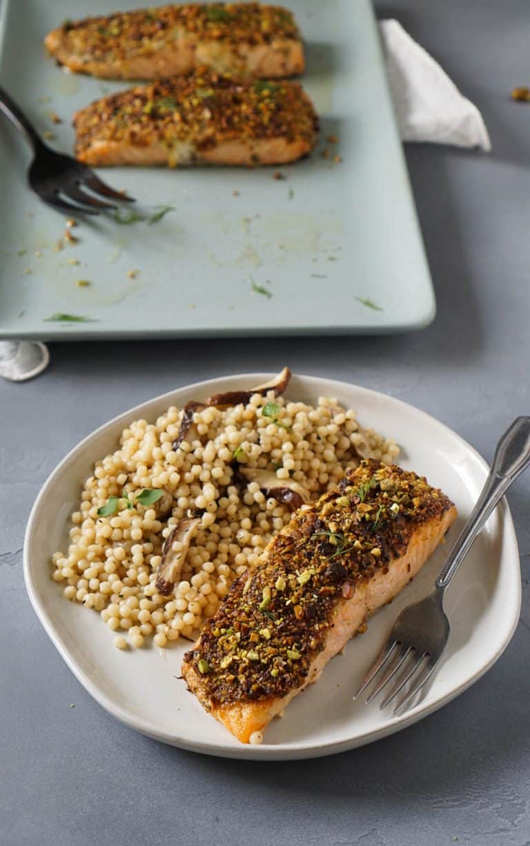 salmon on a white plate with israeli couscous