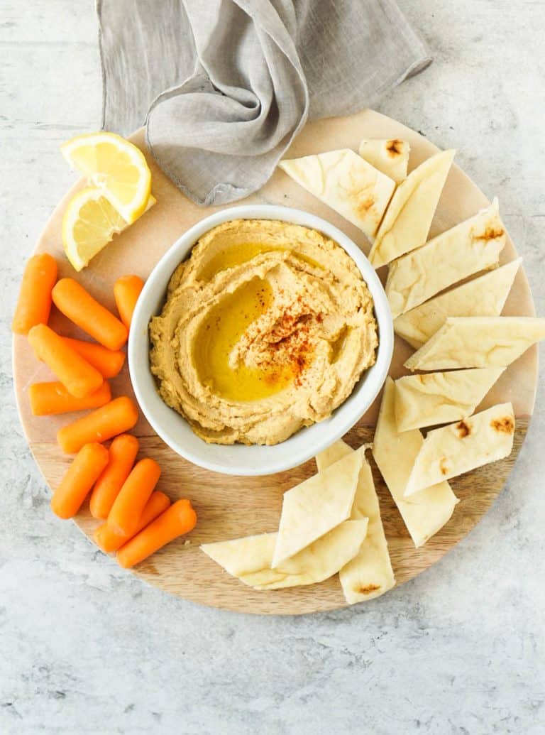 hummus on a platter with carrots and pita