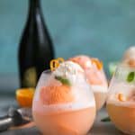 creamsicle floats in stemless glasses with a bottle of prosecco
