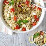 couscous salad in 2 small bowls and 1 large bowl