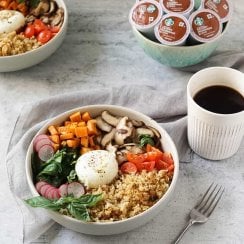 two quinoa breakfast bowls with a cup of coffee and k-cups in a blue bowl