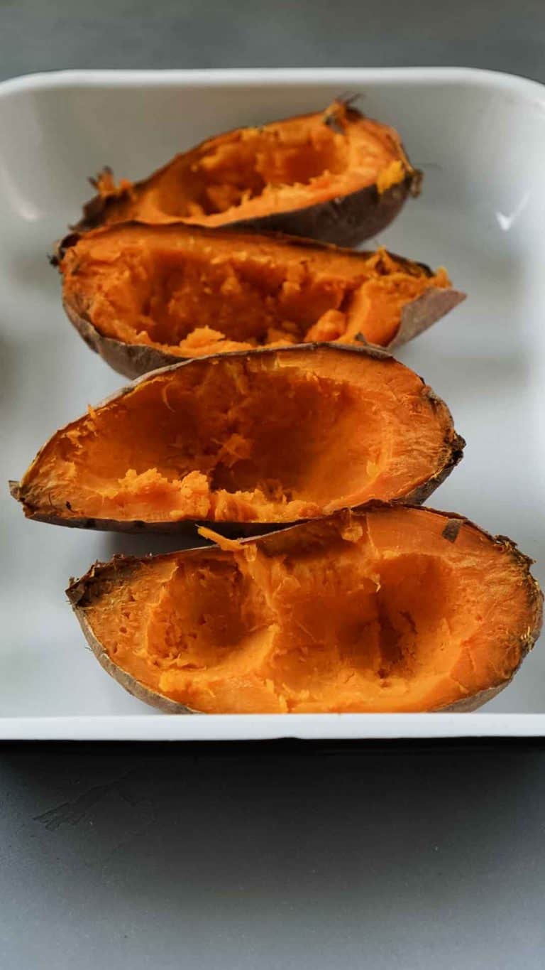 scooped out sweet potatoes in a white baking dish