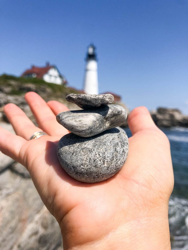 a hand holding 3 small rocks