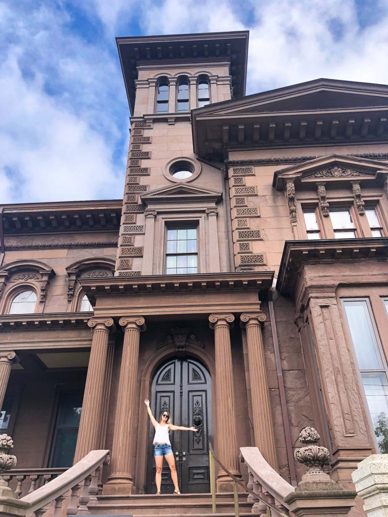 a girl standing outside the victoria mansion in portland maine