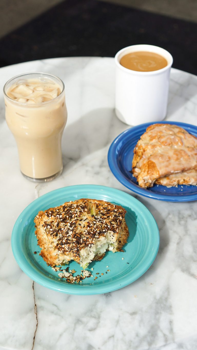 two cups of coffee and two scones on a marble table