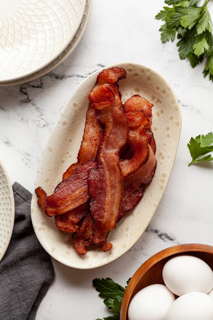 Air fryer bacon in a white dish.