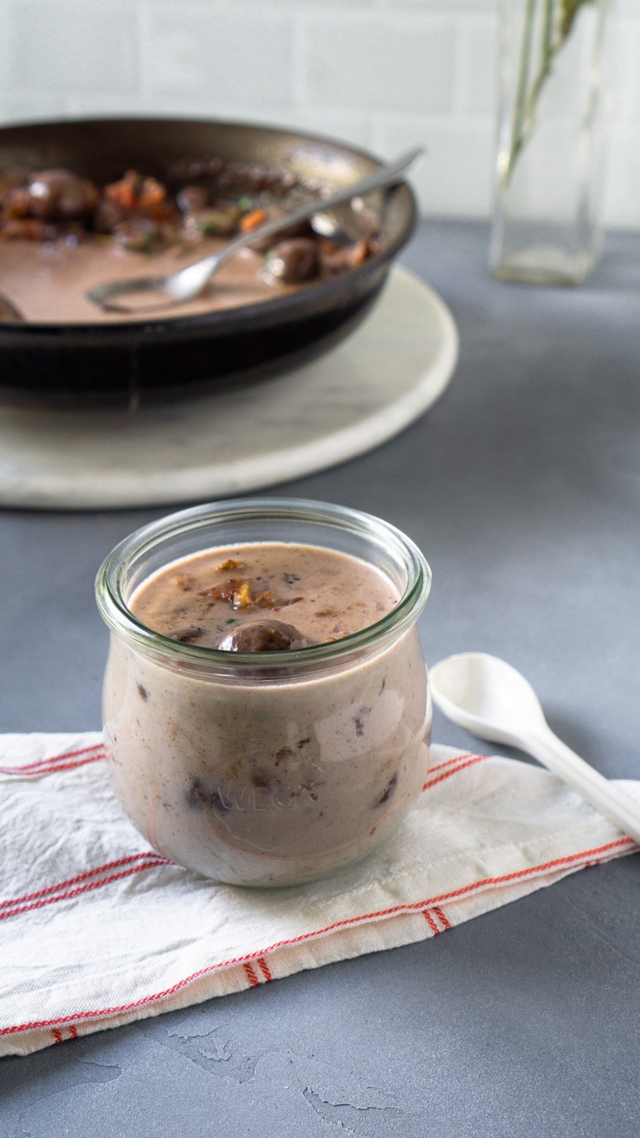 Mushroom bacon gravy in a weck jar with a small white spoon.