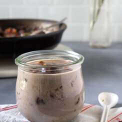 bacon gravy in a small glass jar and a white spoon