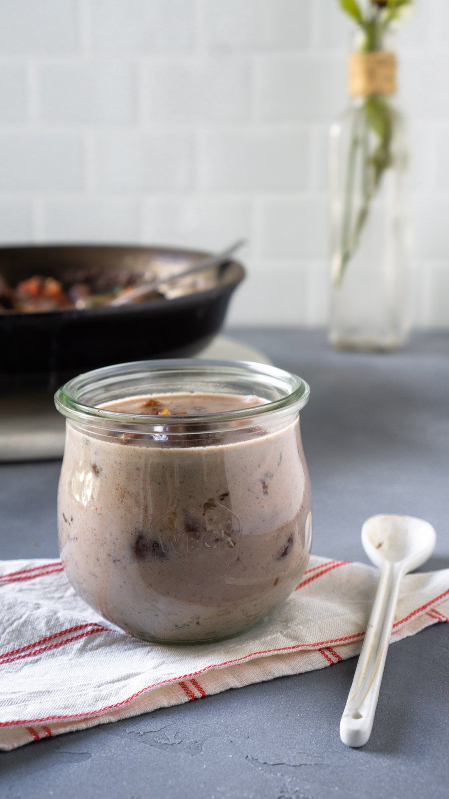 bacon gravy in a small glass jar and a white spoon