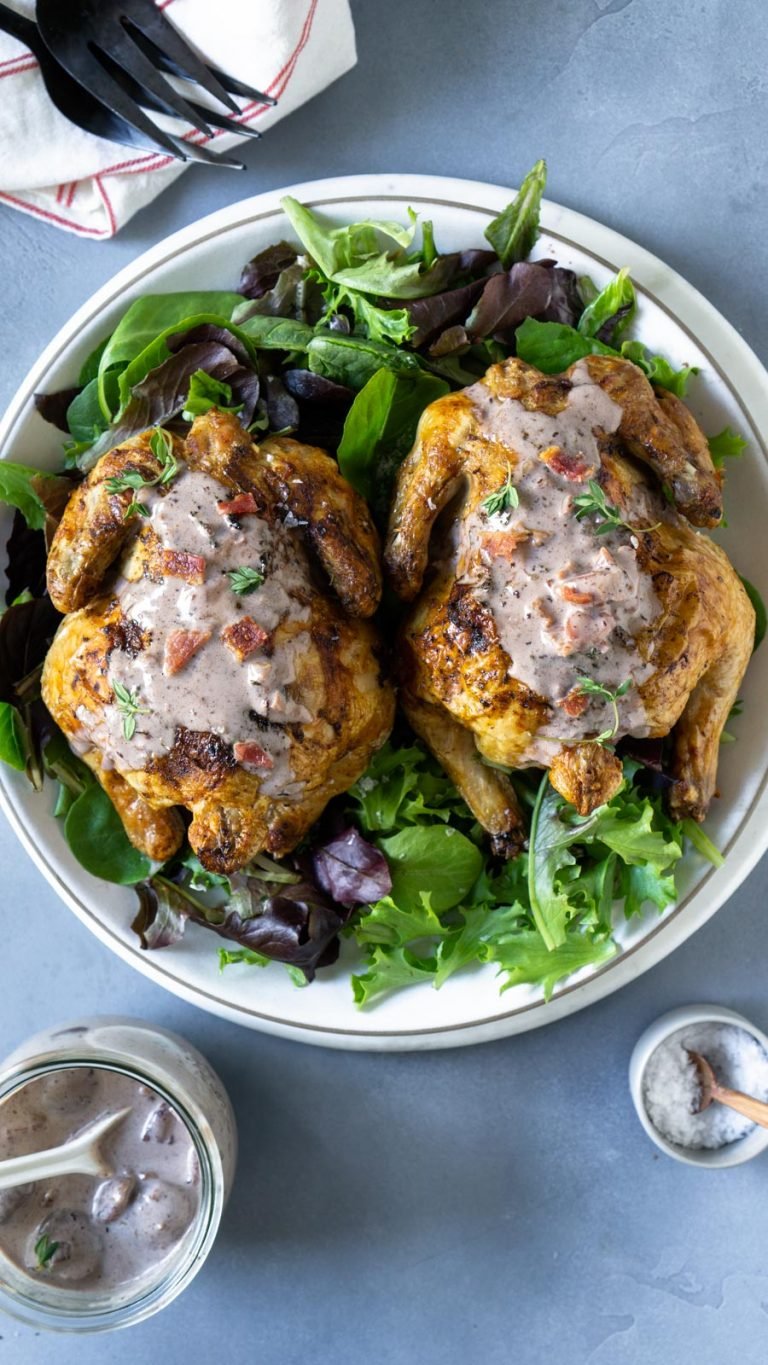 two cornish hens with bacon gravy on a plate with lettuce