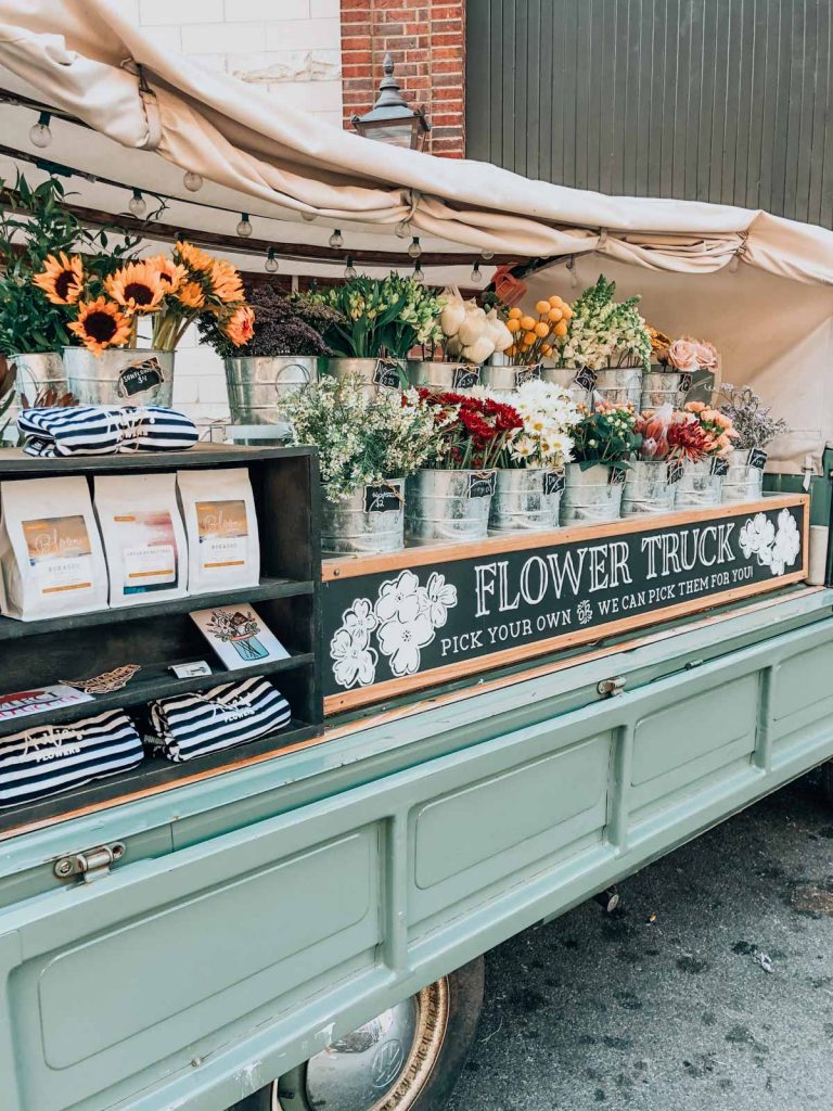 a flower stand on a light blue truck