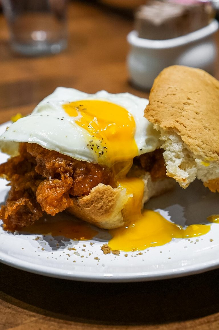 fried chicken sandwich with an egg and yolk dripping