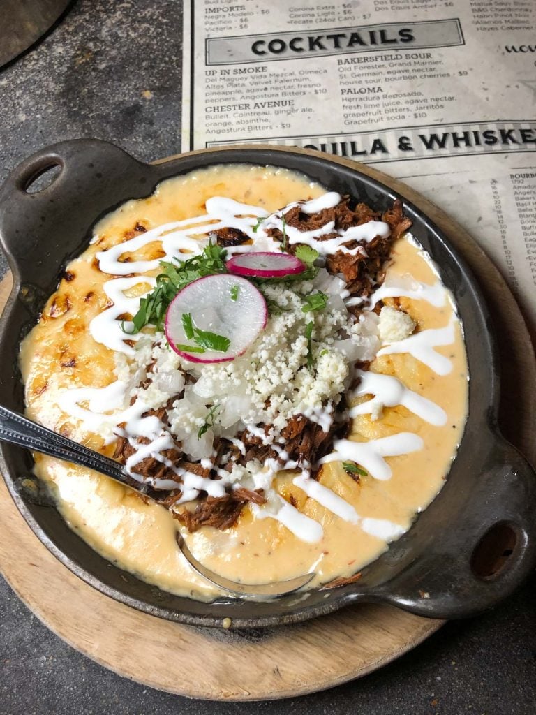 queso dip in a small cast iron pan with a spoon