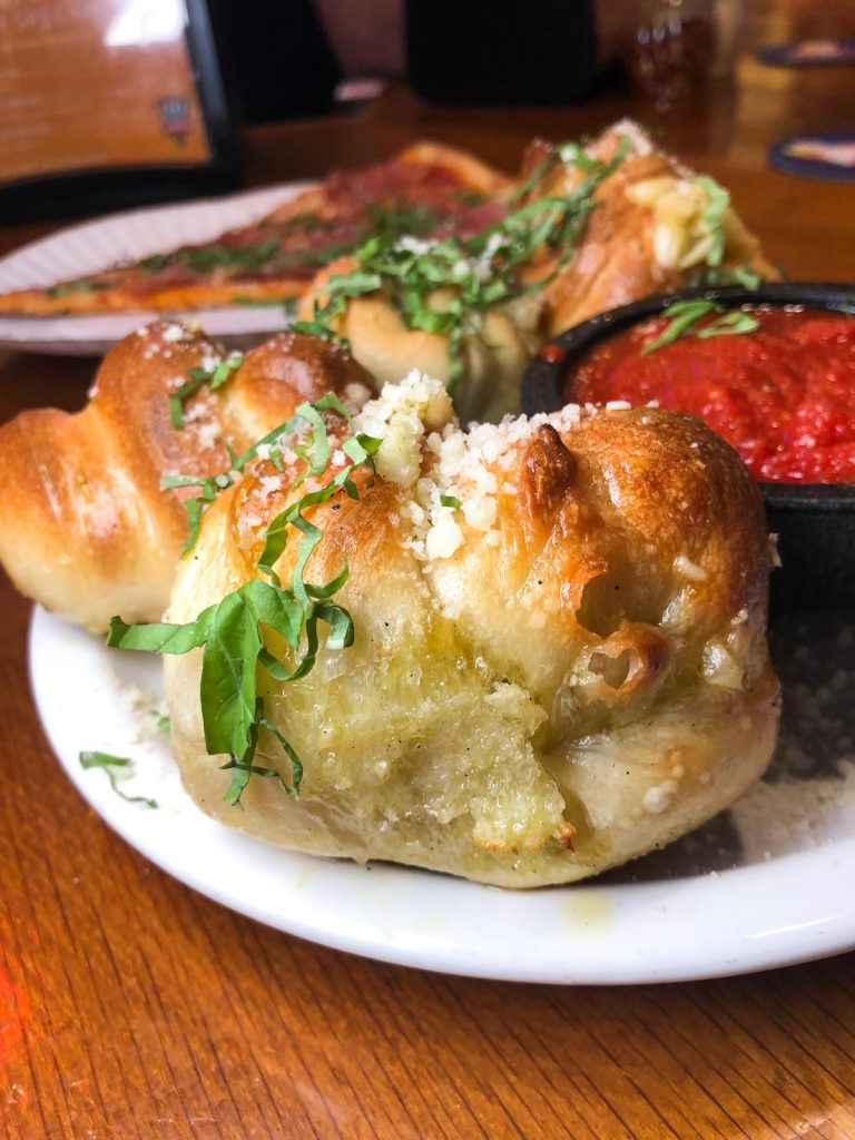 garlic knots on a white plate with marinara sauce