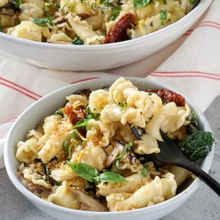 two bowls of tuscan kale pasta with a black fork