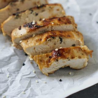 sesame ginger chicken sliced on parchment paper