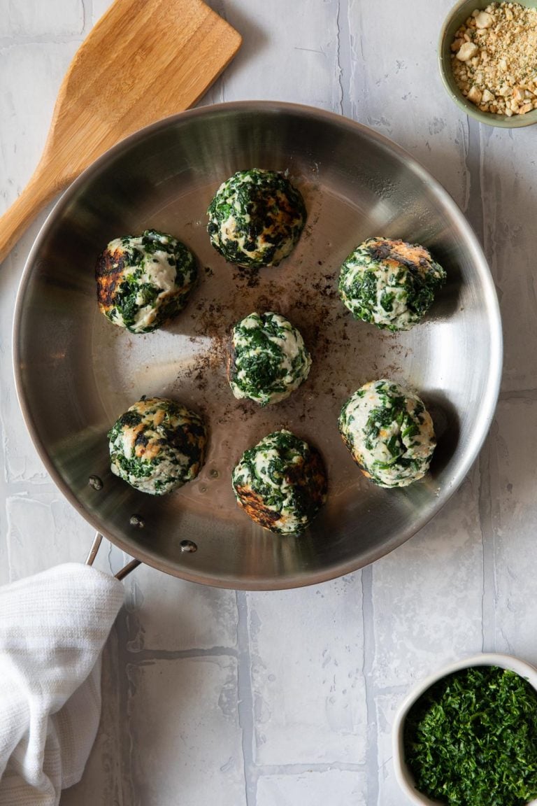 ground turkey meatballs in a pan with a wooden spatula