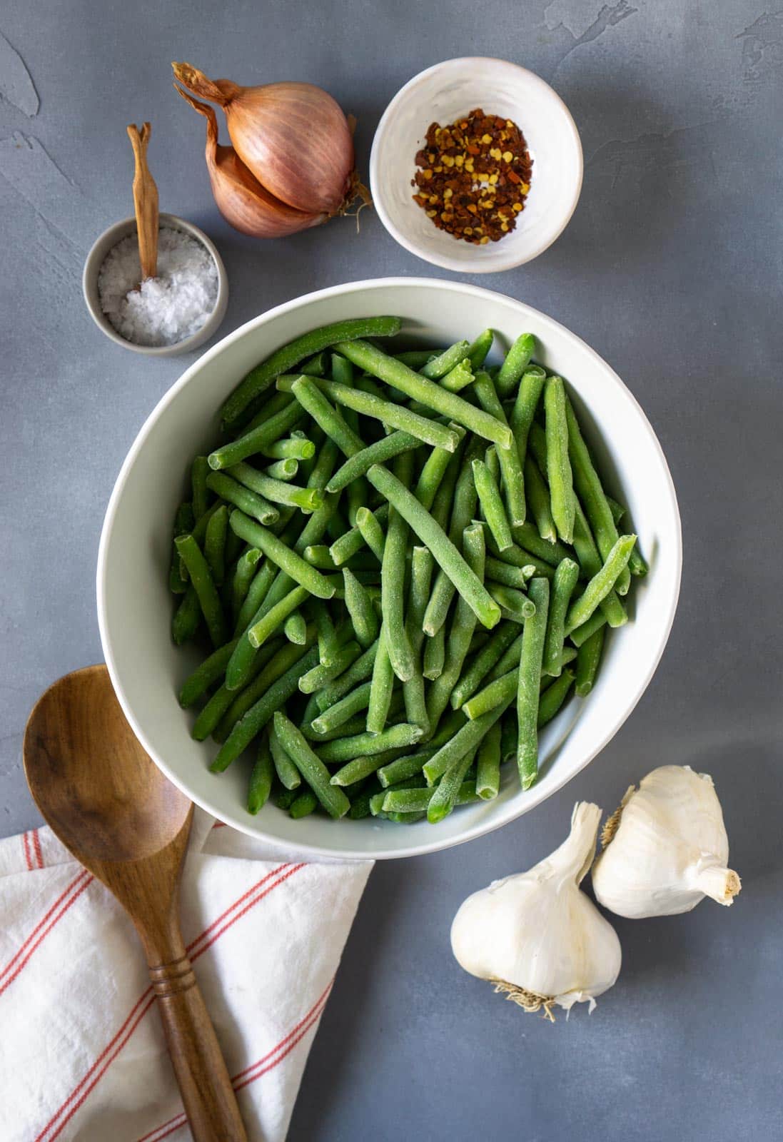 Overhead shot of green beans in a bowl, next to the other ingredients needed,