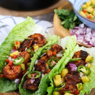 3 tacos on a wooden cutting board