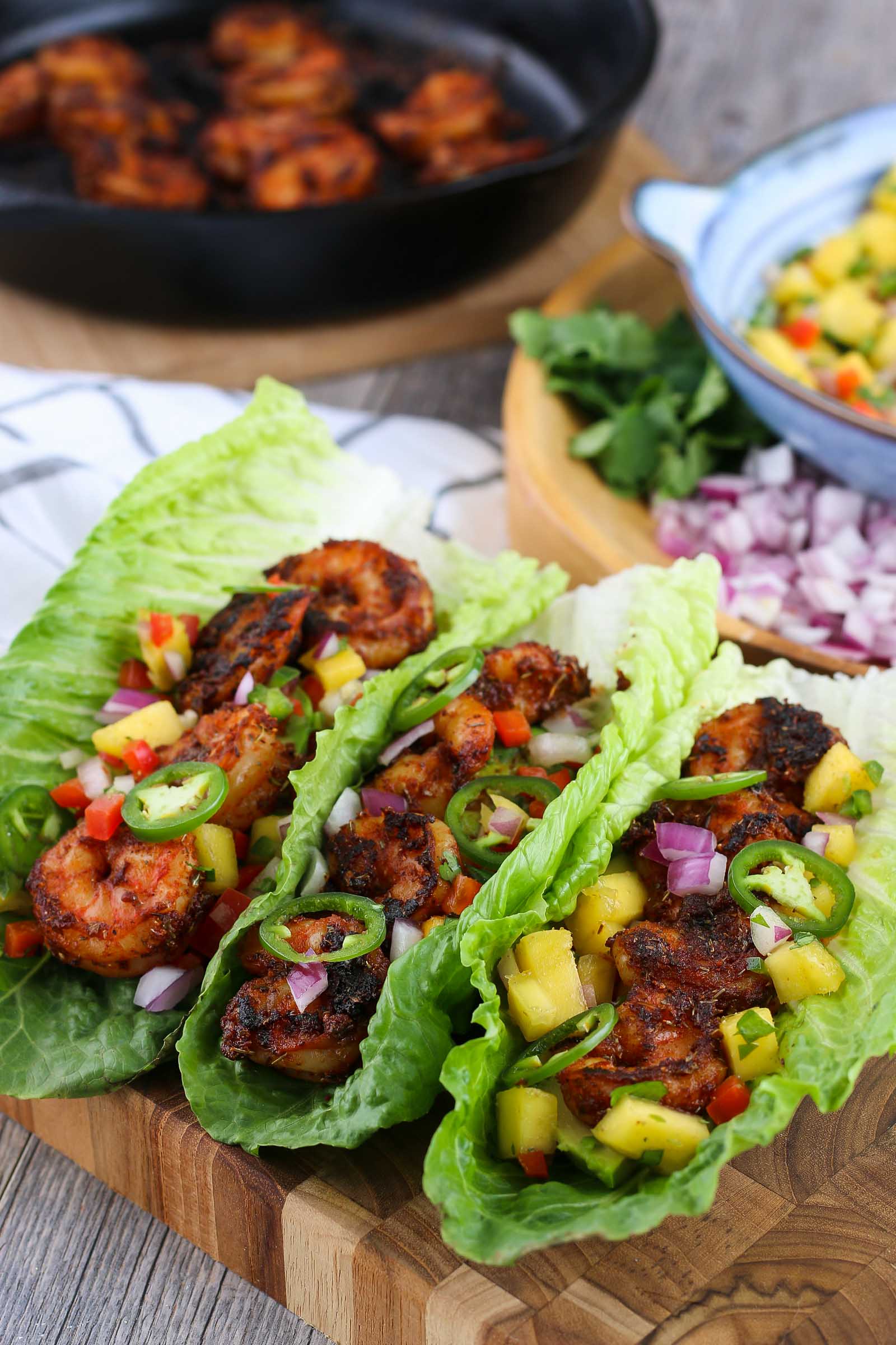 3 tacos on a wooden cutting board