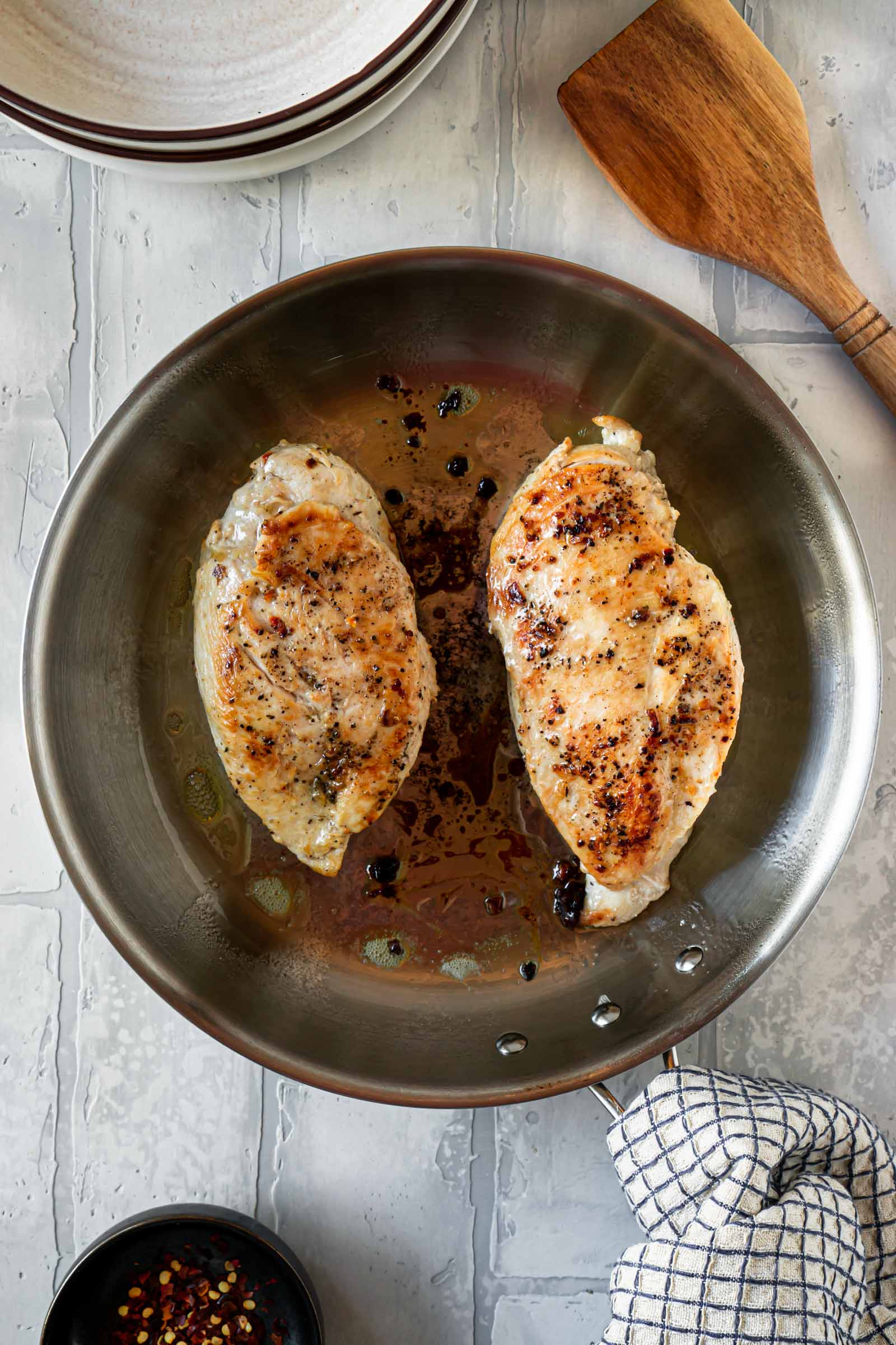 two seared chicken breasts in a pan