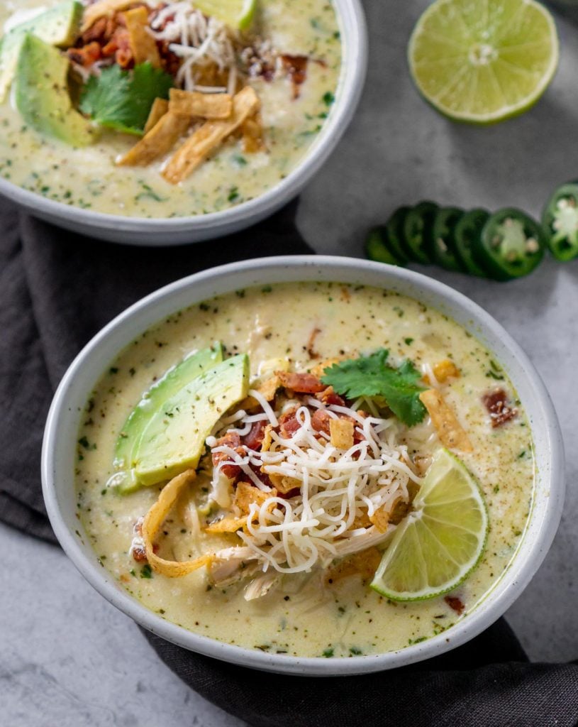 mexican street corn white chicken chili in two bowls, and half a lime
