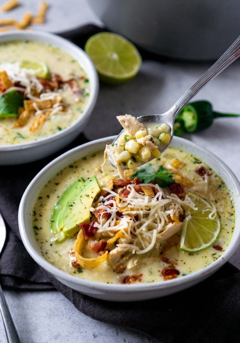 a spoon lifting a bite of chicken chili out of a bowl